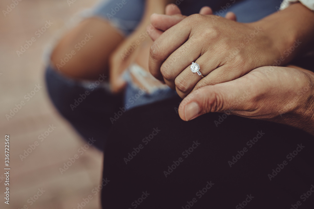 Married couple sitting together holding hands