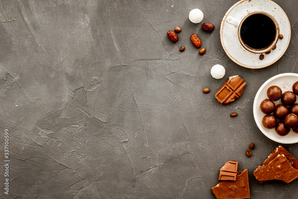 Candy background with chocolate and coffee on grey desk top view frame. Pastry, confectionery concep