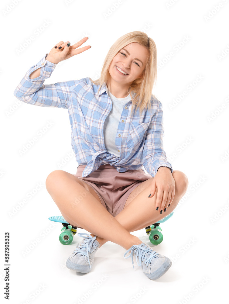 Beautiful young woman with skateboard on white background