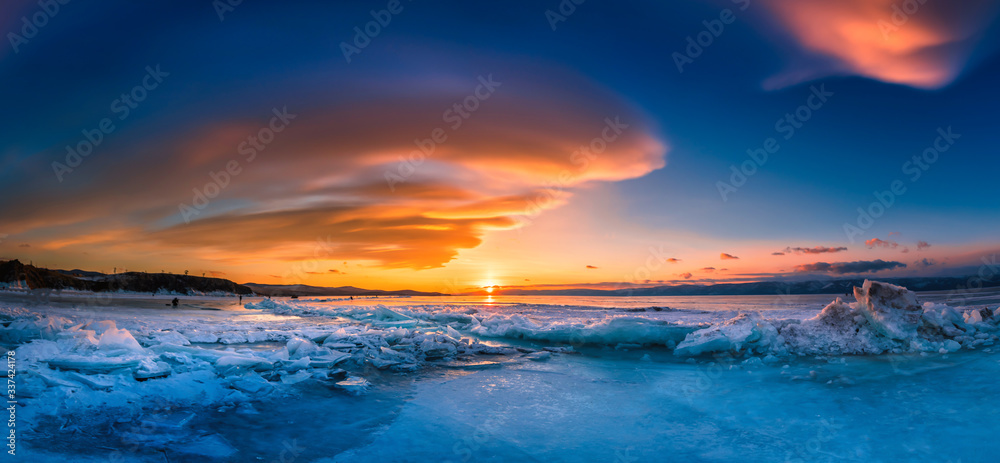 Sunset sky with natural breaking ice over frozen water on Lake Baikal, Siberia, Russia.