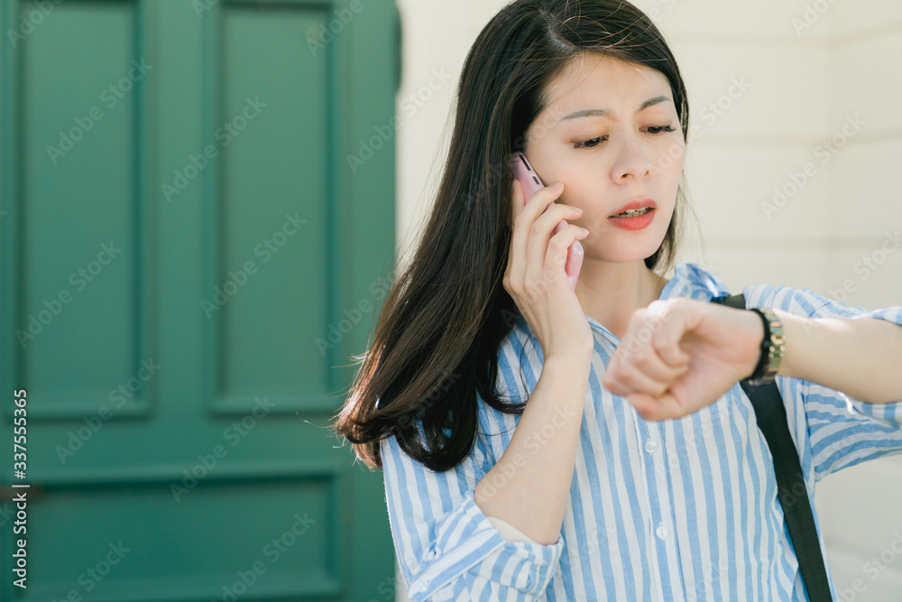 woman checking time talking on mobile phone