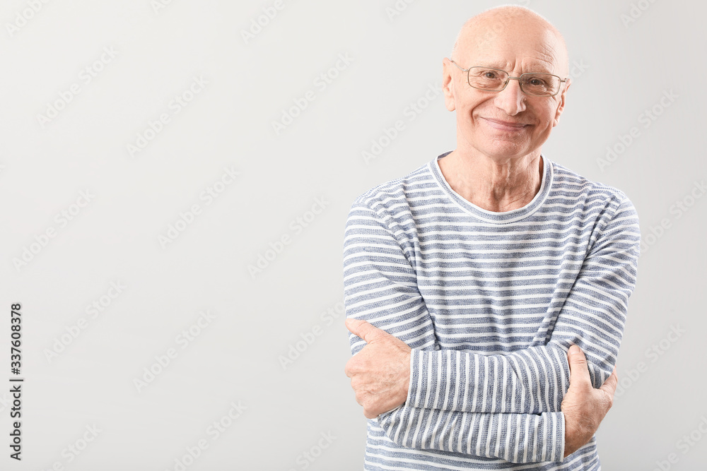 Portrait of elderly man on grey background