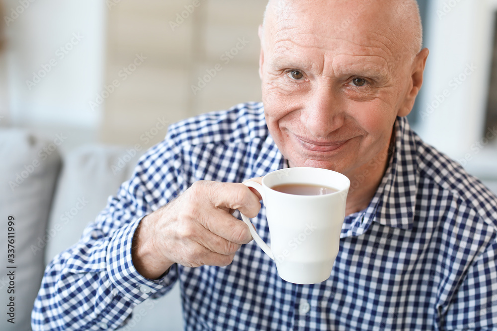 Elderly man drinking tea at home