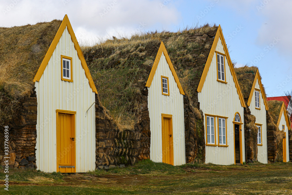 Colored wooden houses made of natural material with grass roof. Authentic landscape of Iceland