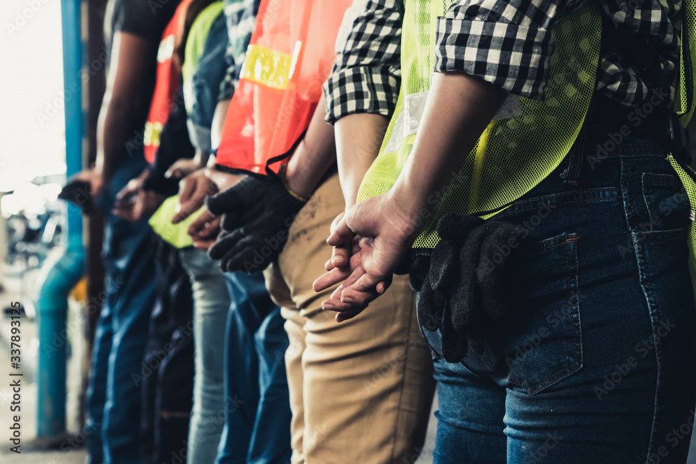 Factory workers standing in a row showing teamwork and unity. Labor and job concept.