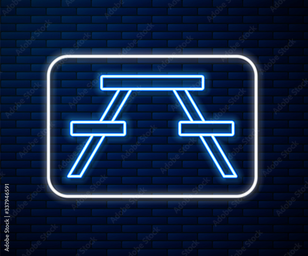 Glowing neon line Picnic table with benches on either side of the table icon isolated on brick wall 