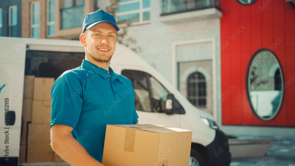 Portrait of Handsome Delivery Man Holds Cardboard Box Package Standing in Modern Stylish Business Di