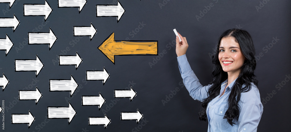 Arrow going in the opposite direction with young woman writing on a blackboard