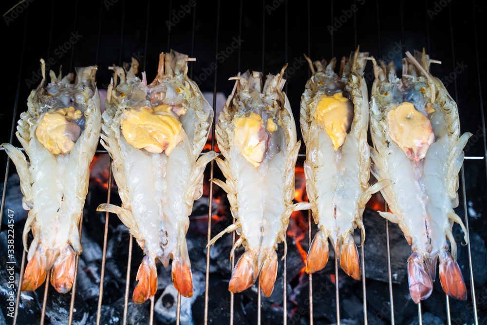 Big prawns, lobsters grilling on barbecue grill coal oven equipment, hot fire below grate . Each hav