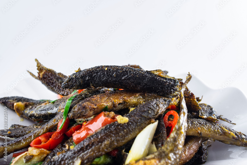 A plate of Hunan home-cooked spicy loach on a white background