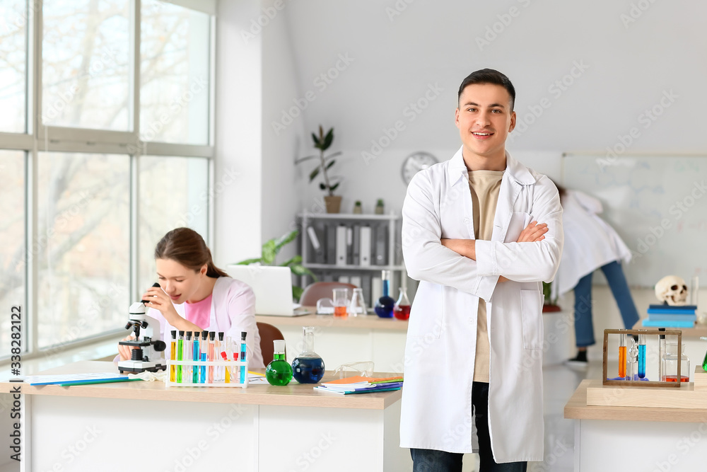 Young man at chemistry lesson in classroom