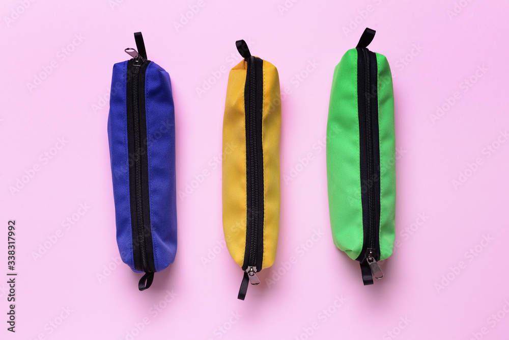 Pencil bags on color background