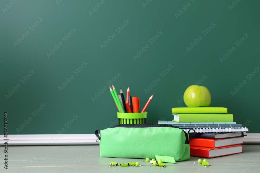 Pencil bag with stationery on desk in classroom