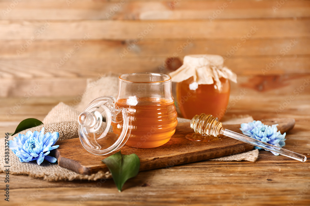 Jar of sweet honey on wooden background