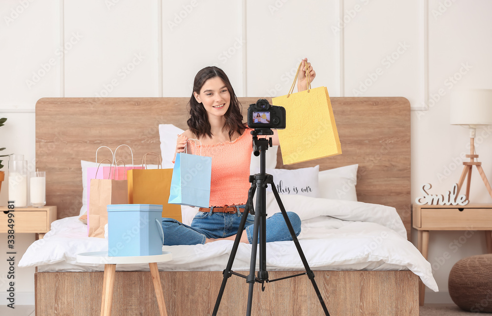 Young fashion blogger recording video at home