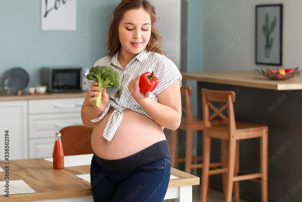 厨房里有健康食品的漂亮孕妇