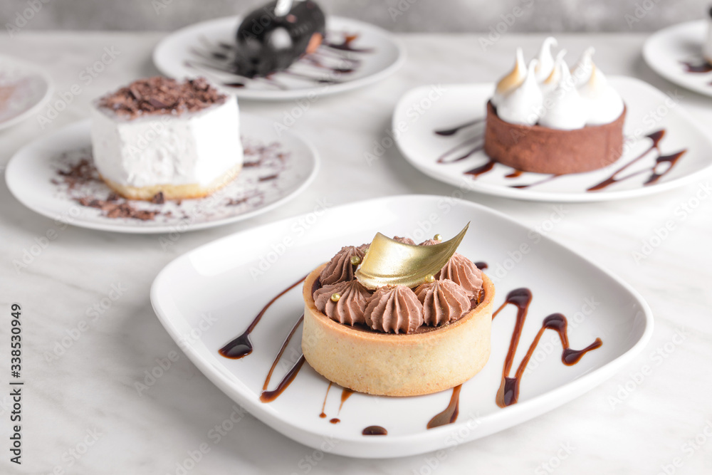 Plate with tasty cake on white table