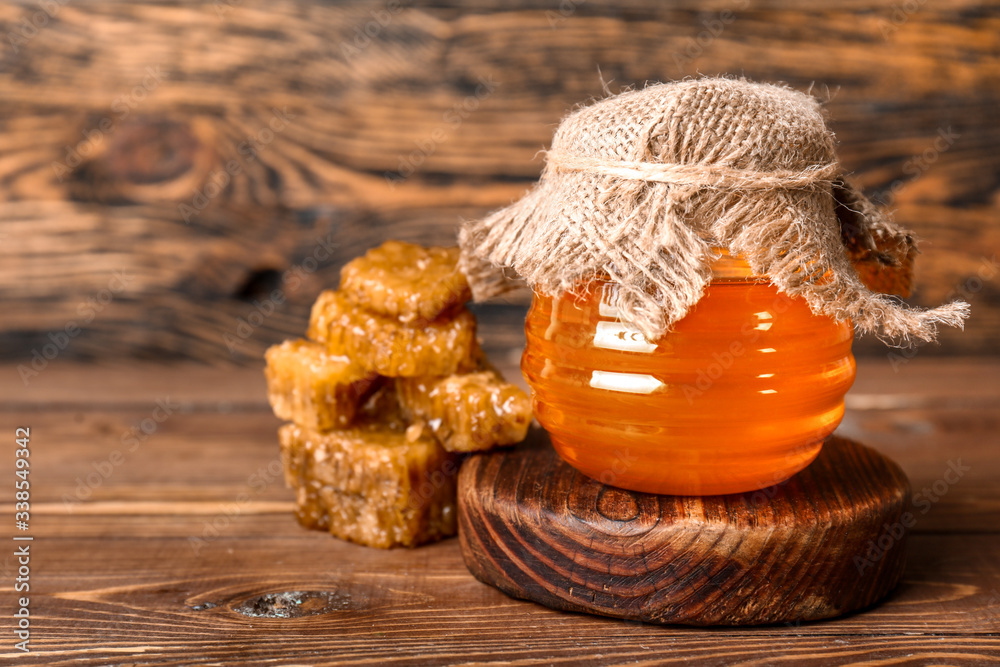 Jar of sweet honey on wooden background