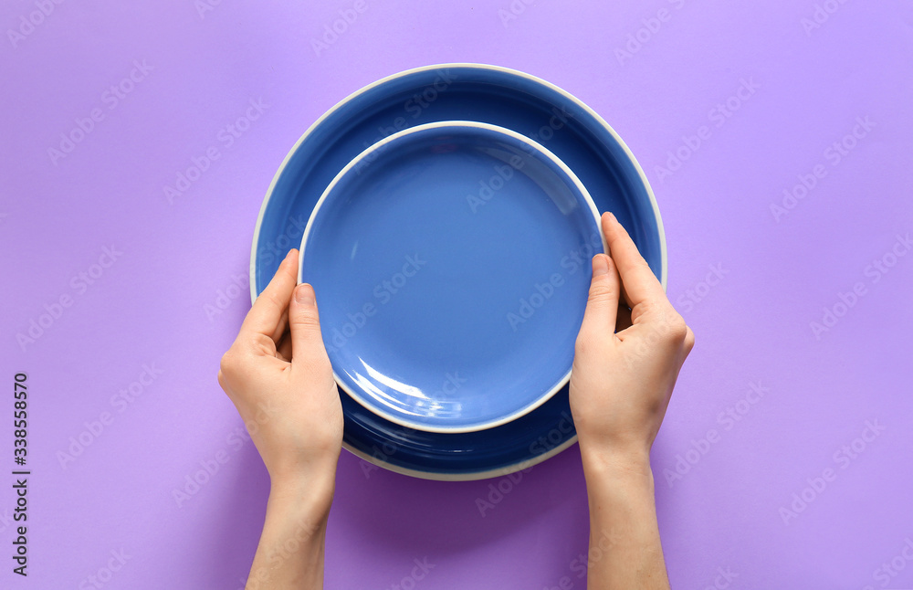 Woman at table with clean plates, top view