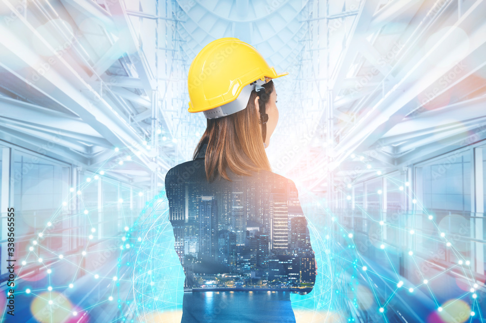 Double exposure of the Business woman in engineering standing against build structure and futuristic