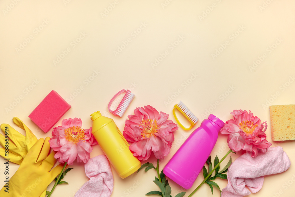 Set of cleaning supplies and spring flowers on color background