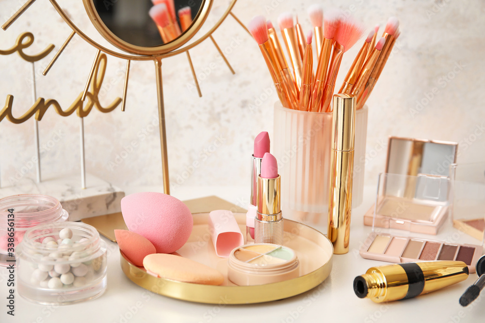 Decorative cosmetics with makeup brushes on dressing table