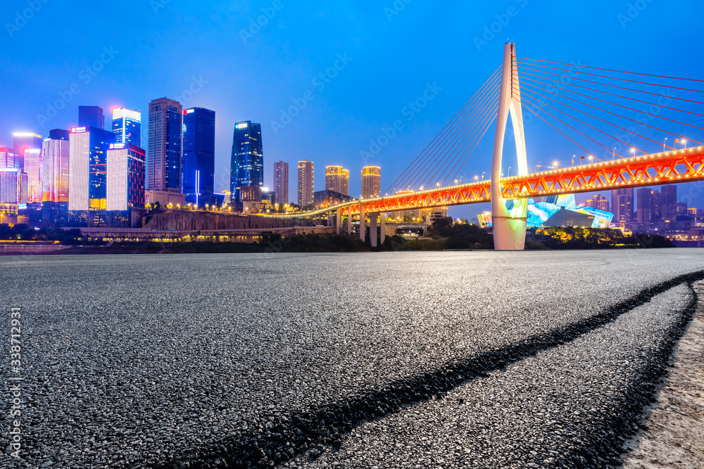 中国重庆，空旷的柏油路和城市天际线，夜晚有建筑。