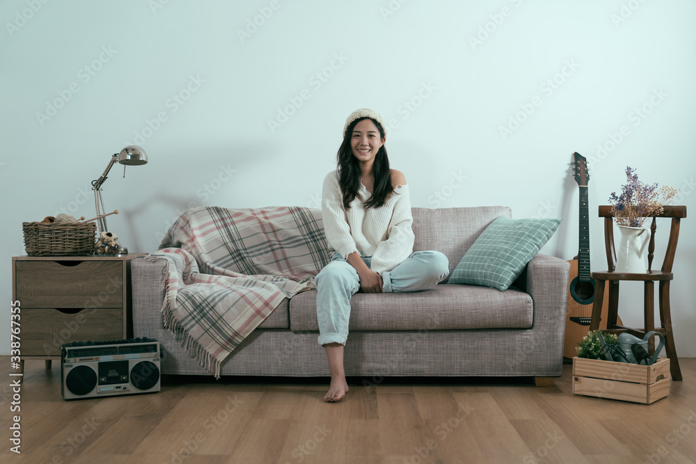 beautiful asian korean woman in sweater relax sitting on sofa face camera smiling with white blank b