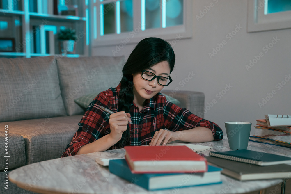 戴着塑料眼镜架的亚洲女学生在伦敦大学专心学习期末考试