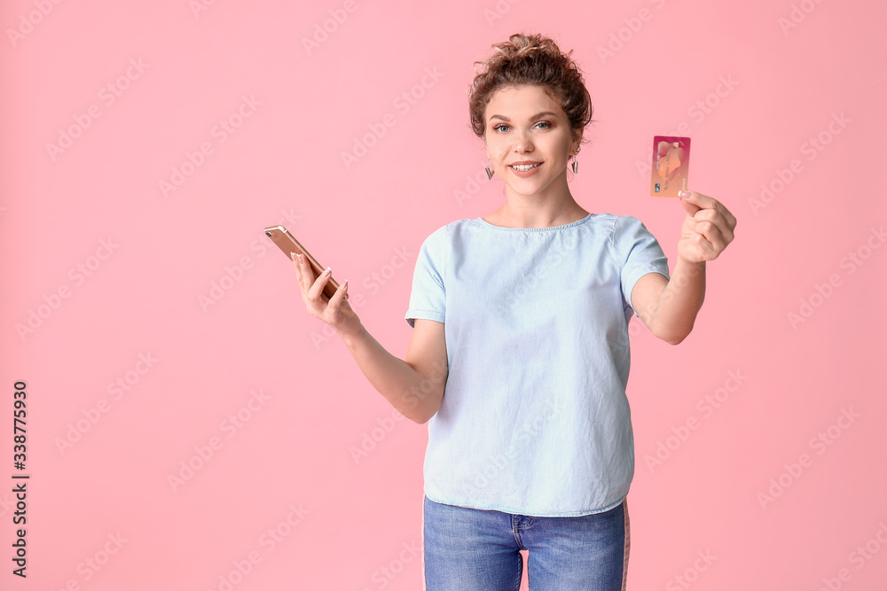 Beautiful young woman with mobile phone and credit card on color background