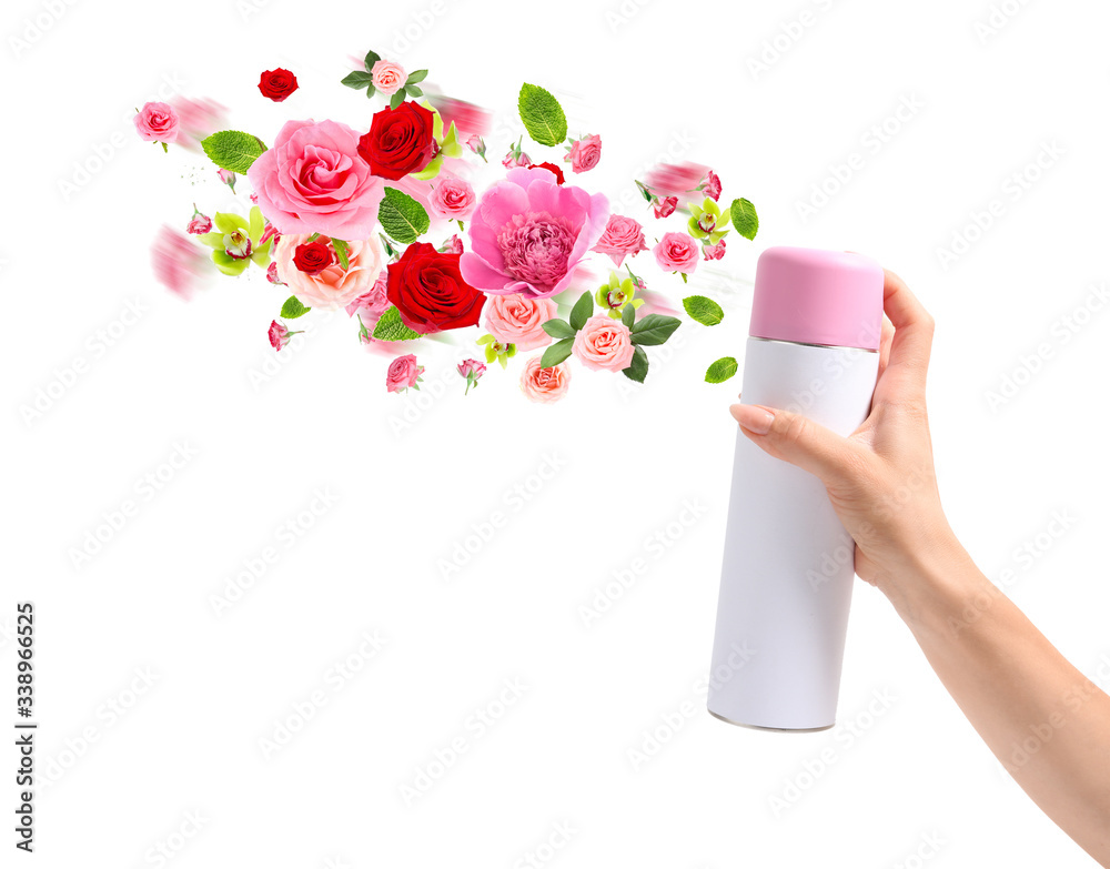 Woman spraying floral air freshener on white background