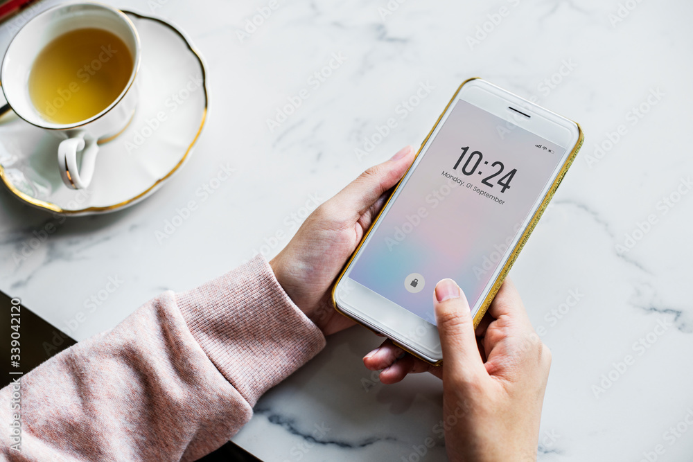 Aerial view of woman using a smart phone and a cup of tea