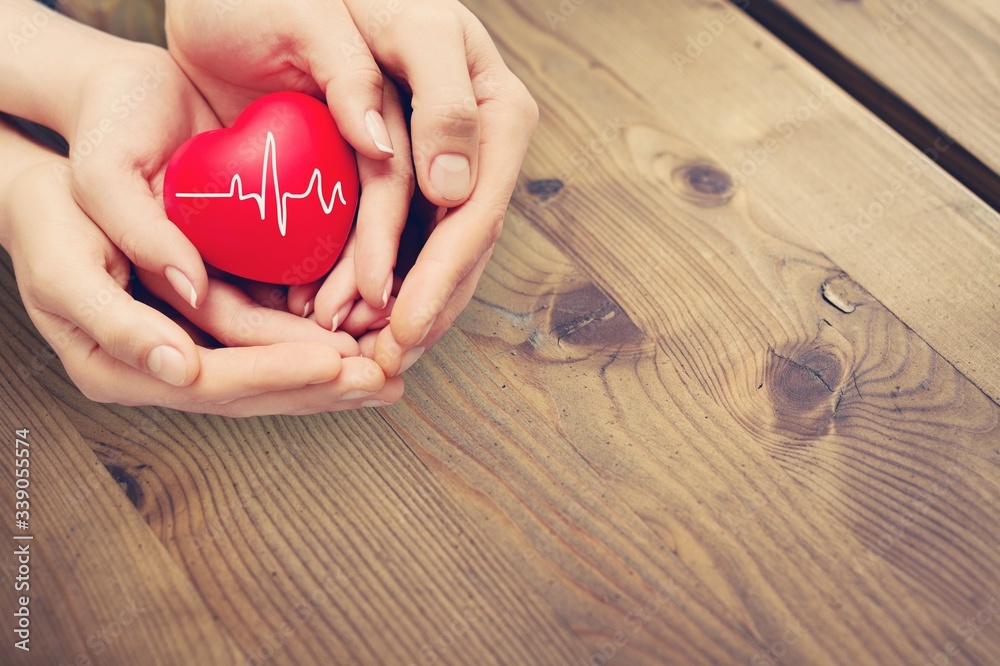 Man and woman hands holding the red heart