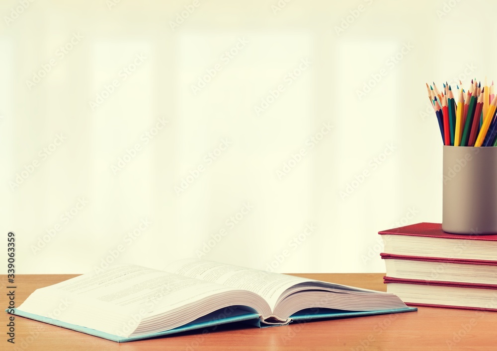 Stack school books with color pencil on desk