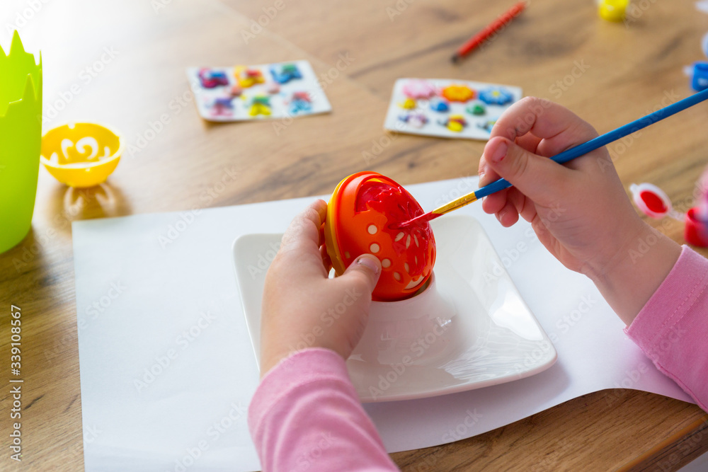 Little girl painting eggs for Easter