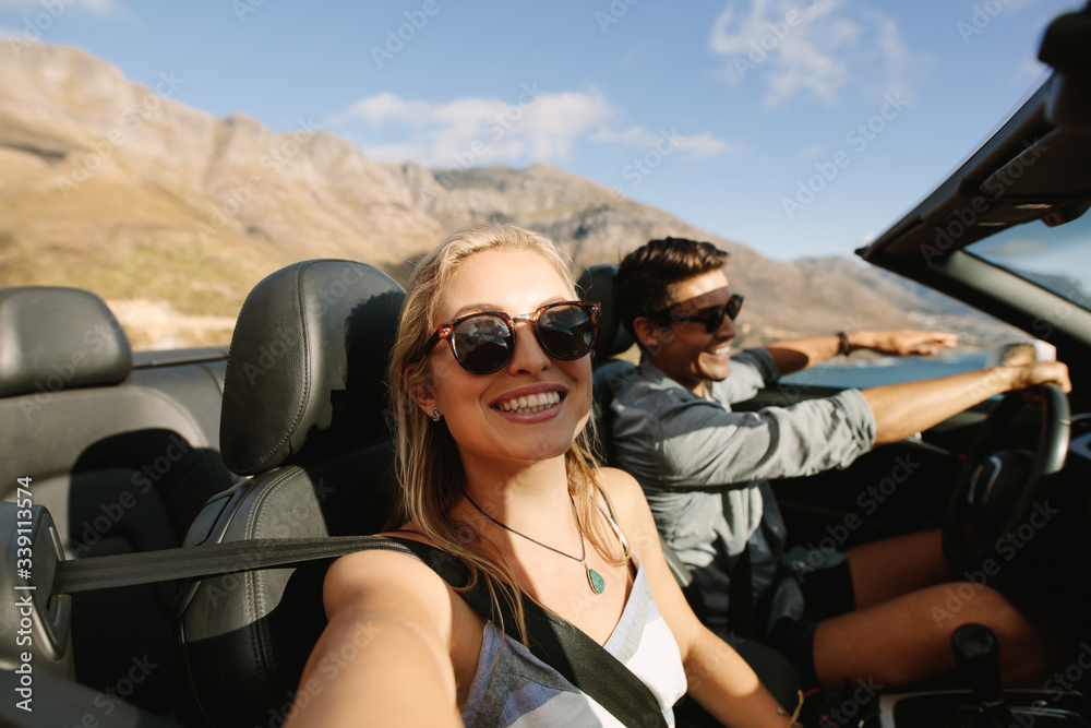 Couple driving in a convertible car