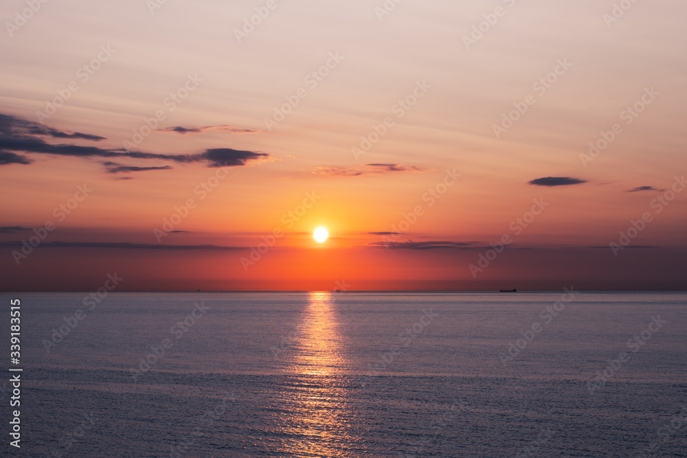 海洋中的日落，柔和的海浪和红色多云的天空。海洋日出背景。风景照片