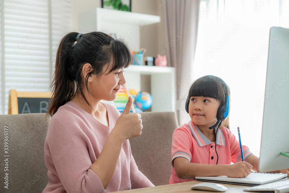 亚洲女学生在视频会议电子学习中，母亲向女儿竖起大拇指