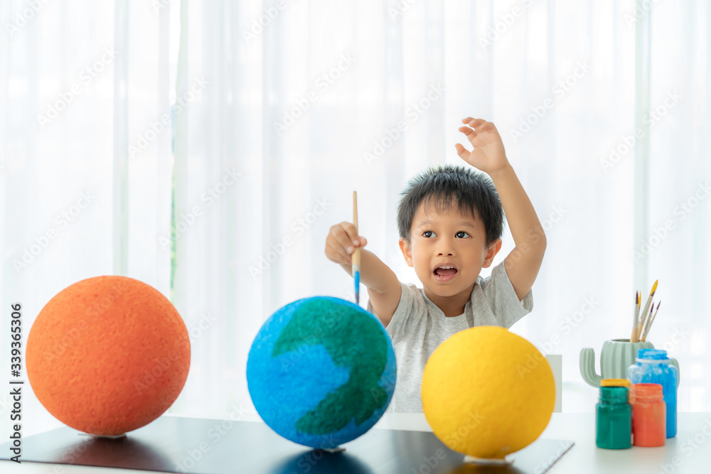 亚洲学前班男孩画月亮，在家学习太阳系，在家上学