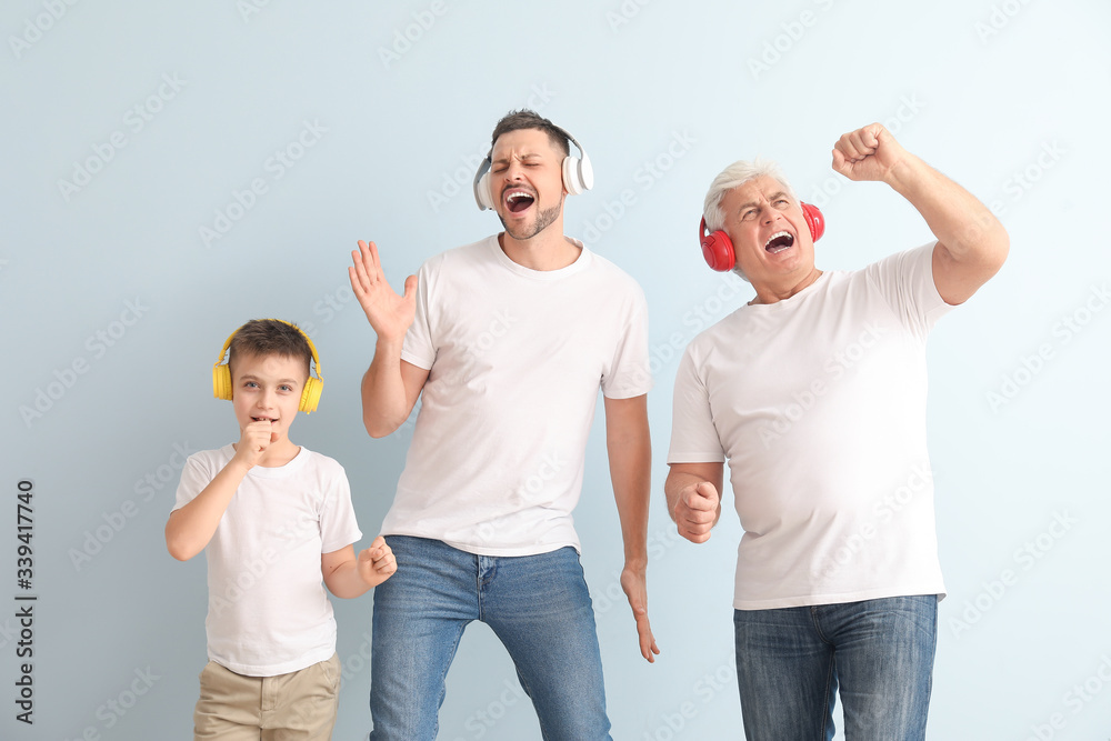 Man with his father and son listening to music on color background