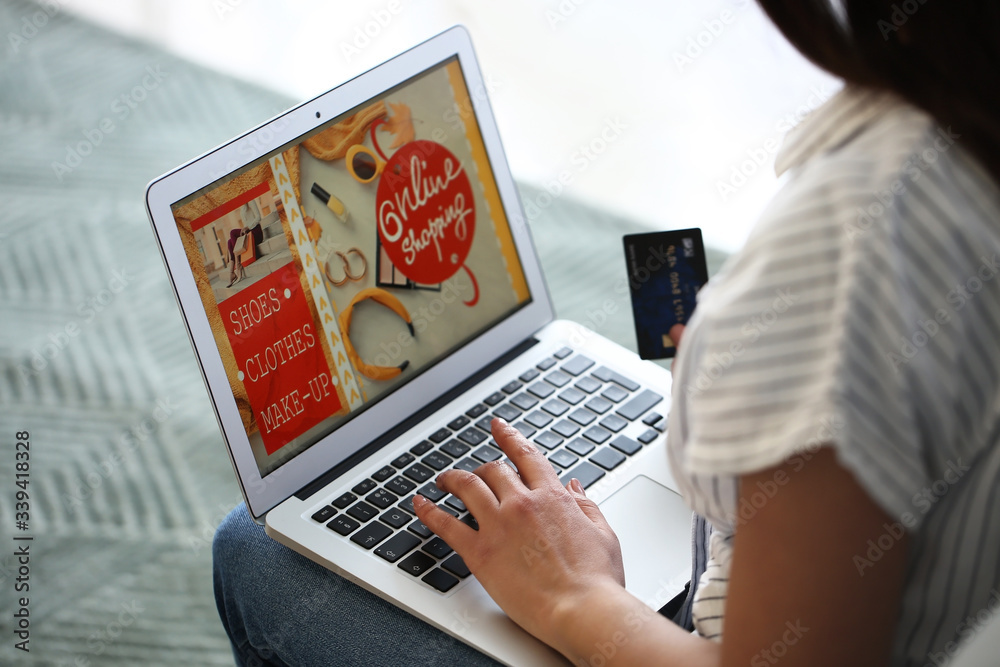 Young woman with laptop and credit card at home. Online shopping concept