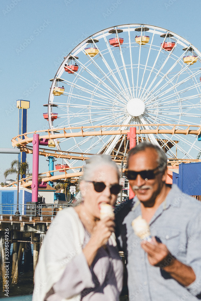 Happy seniors enjoying ice cream by the sea