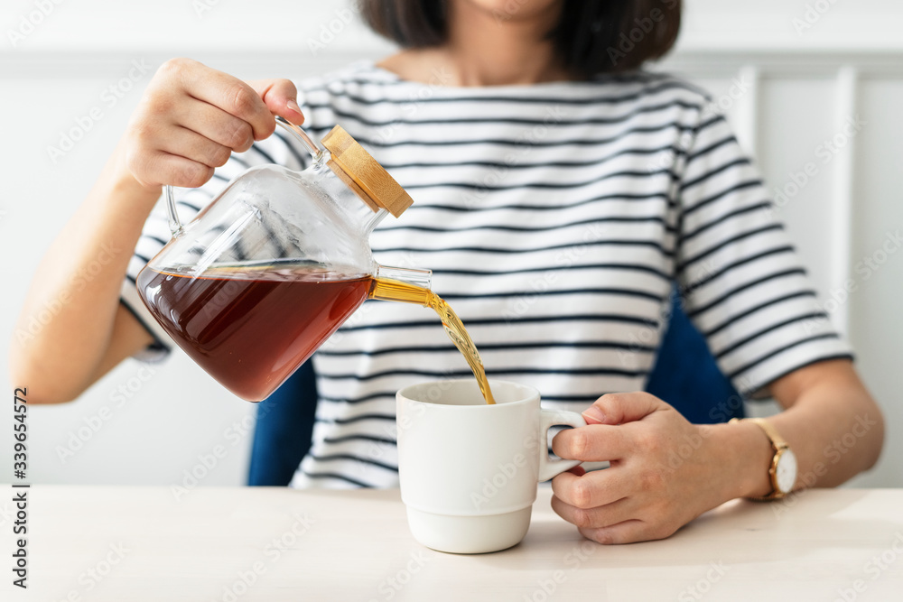 女人往杯子里倒咖啡