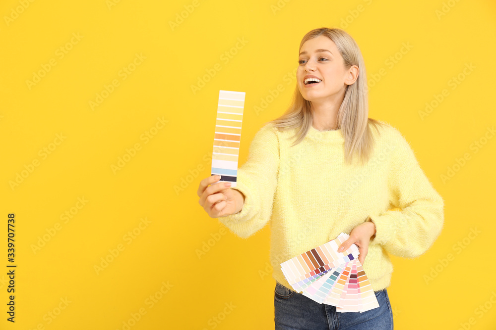 Young woman with paint palette on color background