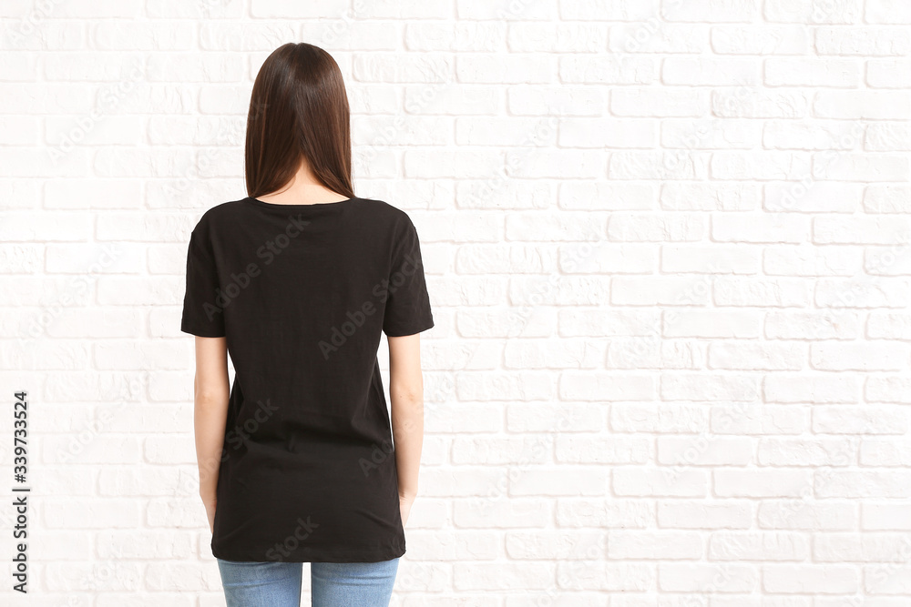 Woman in stylish t-shirt on white brick background