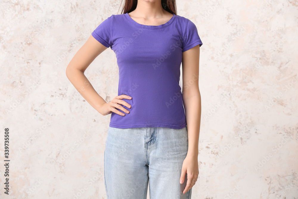 Young woman in stylish t-shirt on light background