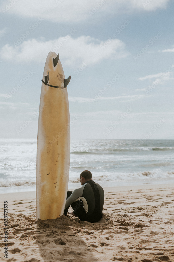 Surfer resting on the beach