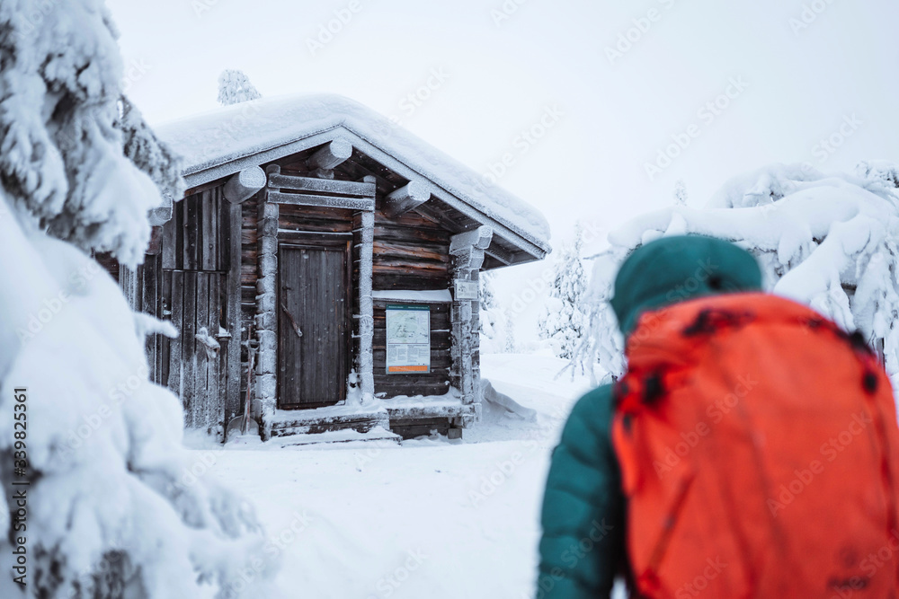 一个女人走向雪地里的小屋