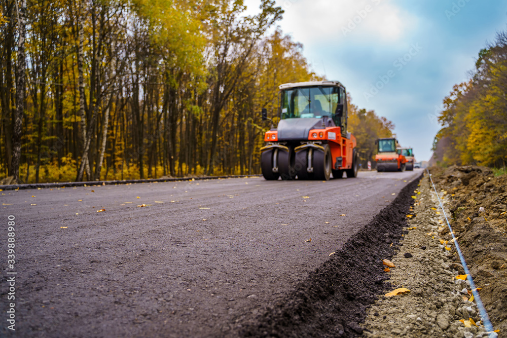 Industrial pavement truck. Laying fresh asphalt on construction site. Heavy machine industry. Mechan