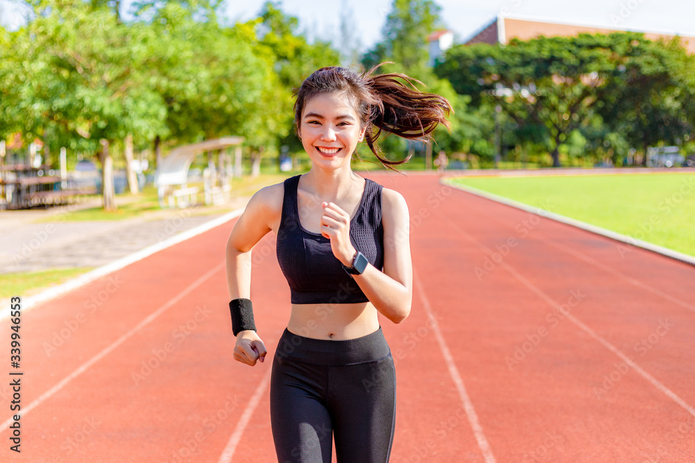 Beautiful young Asian woman exercising in the morning at a running track